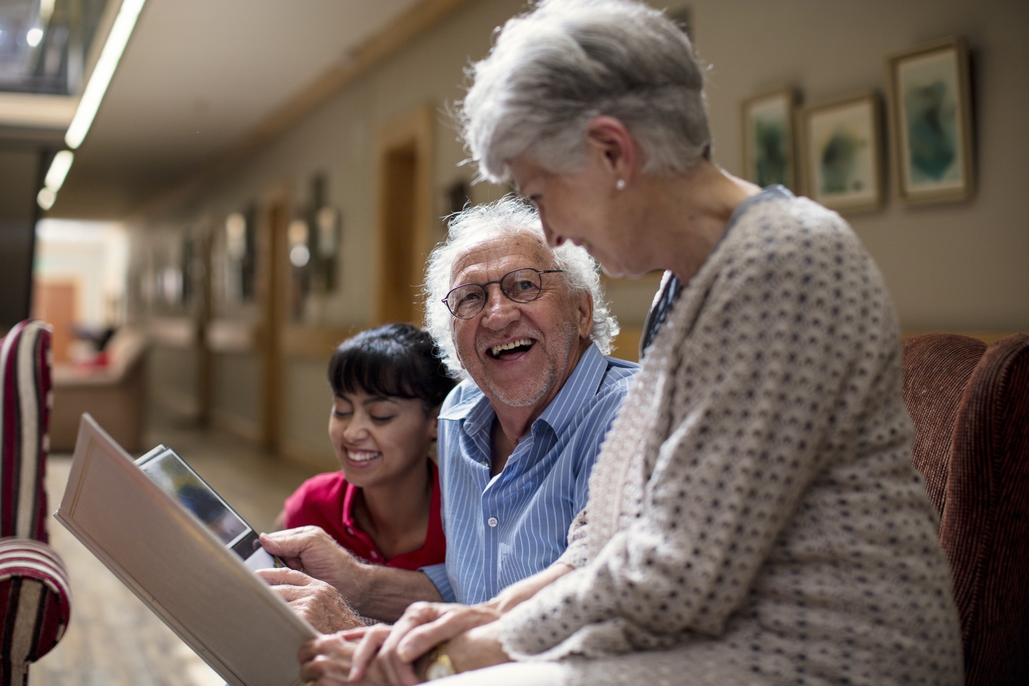 Nurse teaching seniors in retirement home, how to use laptop